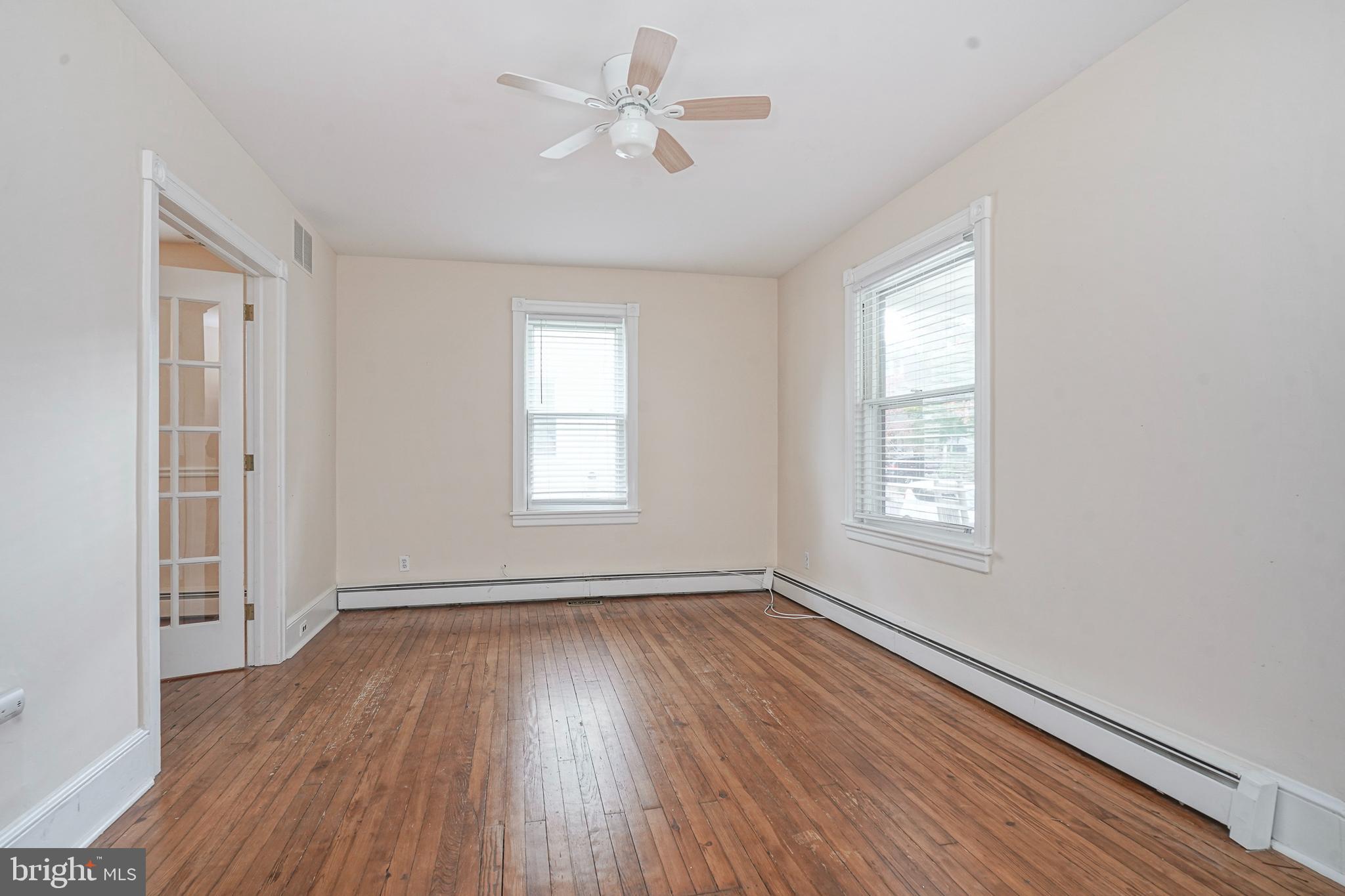 107 Colonial Avenue Haddonfield, NJ 08033 - Photo 6 of 29 an empty room with wooden floor ceiling fan and windows