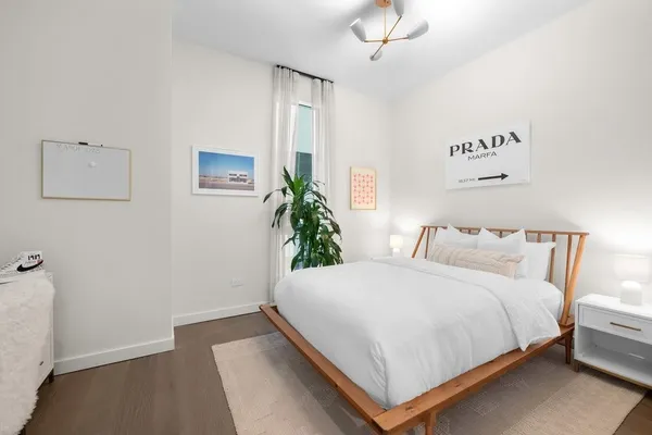 a bedroom with a bed and a potted plant