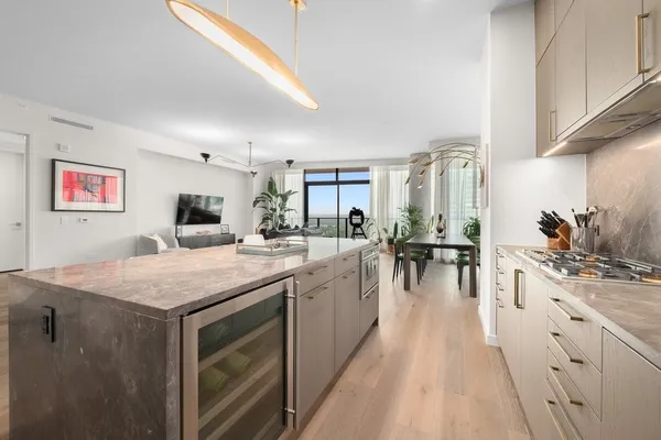 a view of a kitchen with kitchen island a counter top space a sink and cabinets