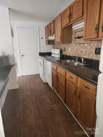 a kitchen with granite countertop cabinets stainless steel appliances a sink and a counter top space