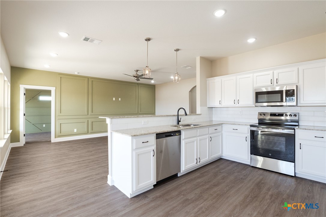 2005 Blackhawk Loop Belton, TX 76513 - Photo 13 of 37 a large kitchen with stainless steel appliances granite countertop a sink a stove a microwave a center island and cabinets