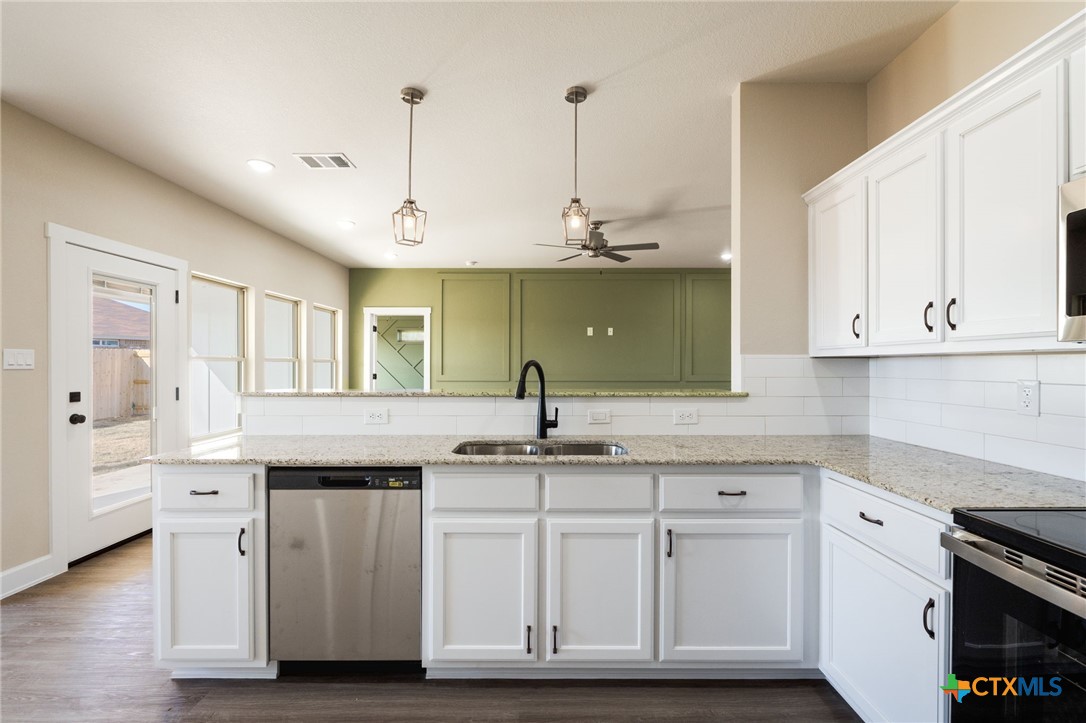 2005 Blackhawk Loop Belton, TX 76513 - Photo 14 of 37 a kitchen with stainless steel appliances granite countertop a sink and cabinets
