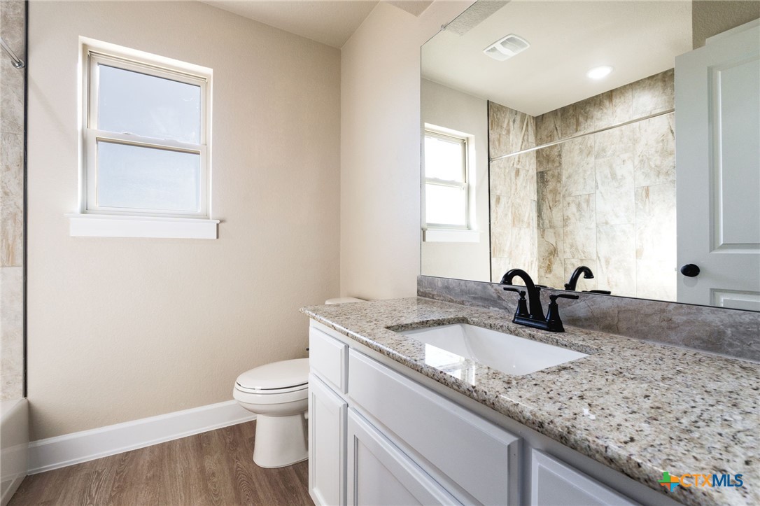 2005 Blackhawk Loop Belton, TX 76513 - Photo 29 of 37 a bathroom with a granite countertop sink a toilet and a window