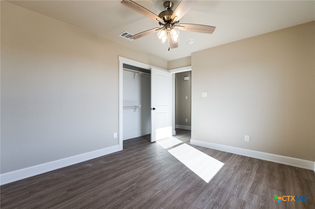 2005 Blackhawk Loop Belton, TX 76513 - Photo 31 of 37 an empty room with wooden floor and ceiling fan