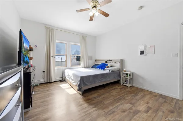 a spacious bedroom with a bed and a flat screen tv