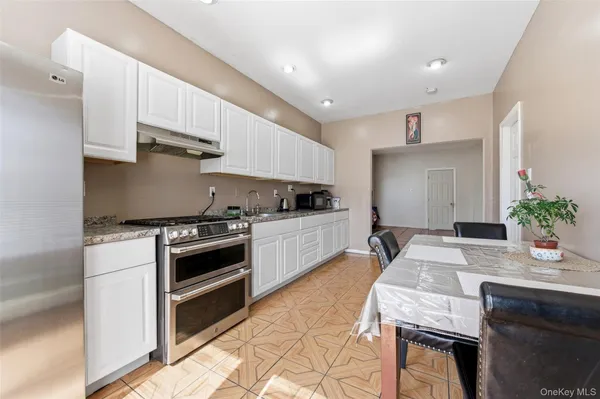 a kitchen with granite countertop a sink stove and cabinets