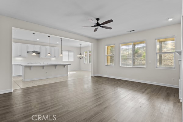 341 Caldera Street Perris, CA 92570 - Photo 36 of 53 a view of an empty room with a kitchen and wooden floor