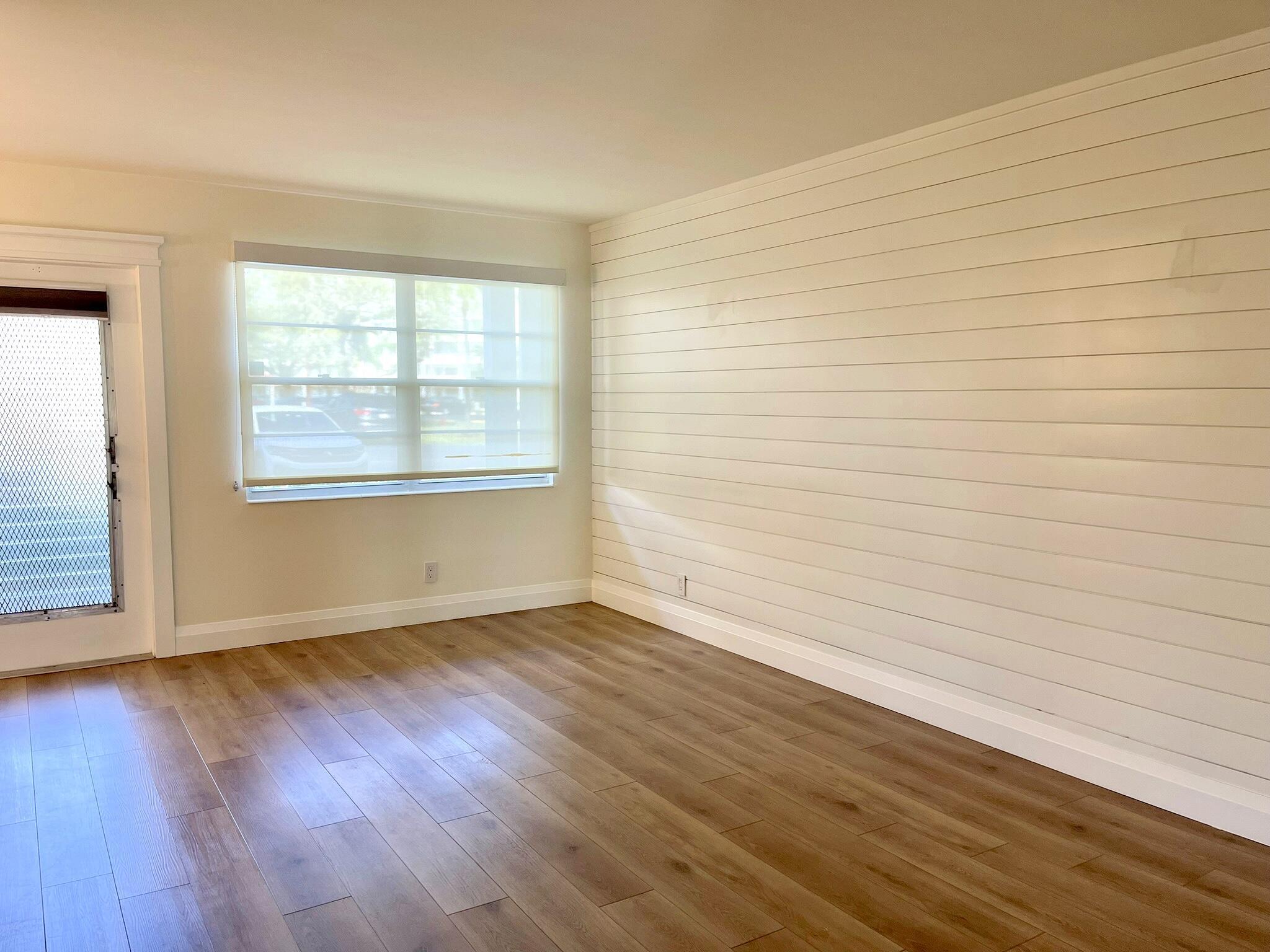 1030 Rexford B Boca Raton, FL 33434 - Photo 4 of 27 an empty room with wooden floor and windows