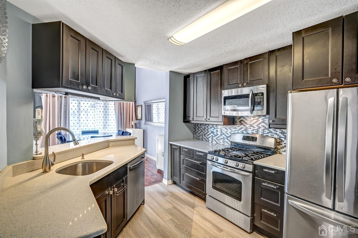 532 Edpas Road New Brunswick, NJ 08901 - Photo 13 of 29 a kitchen with stainless steel appliances granite countertop a stove a sink dishwasher a refrigerator and cabinets with wooden floor