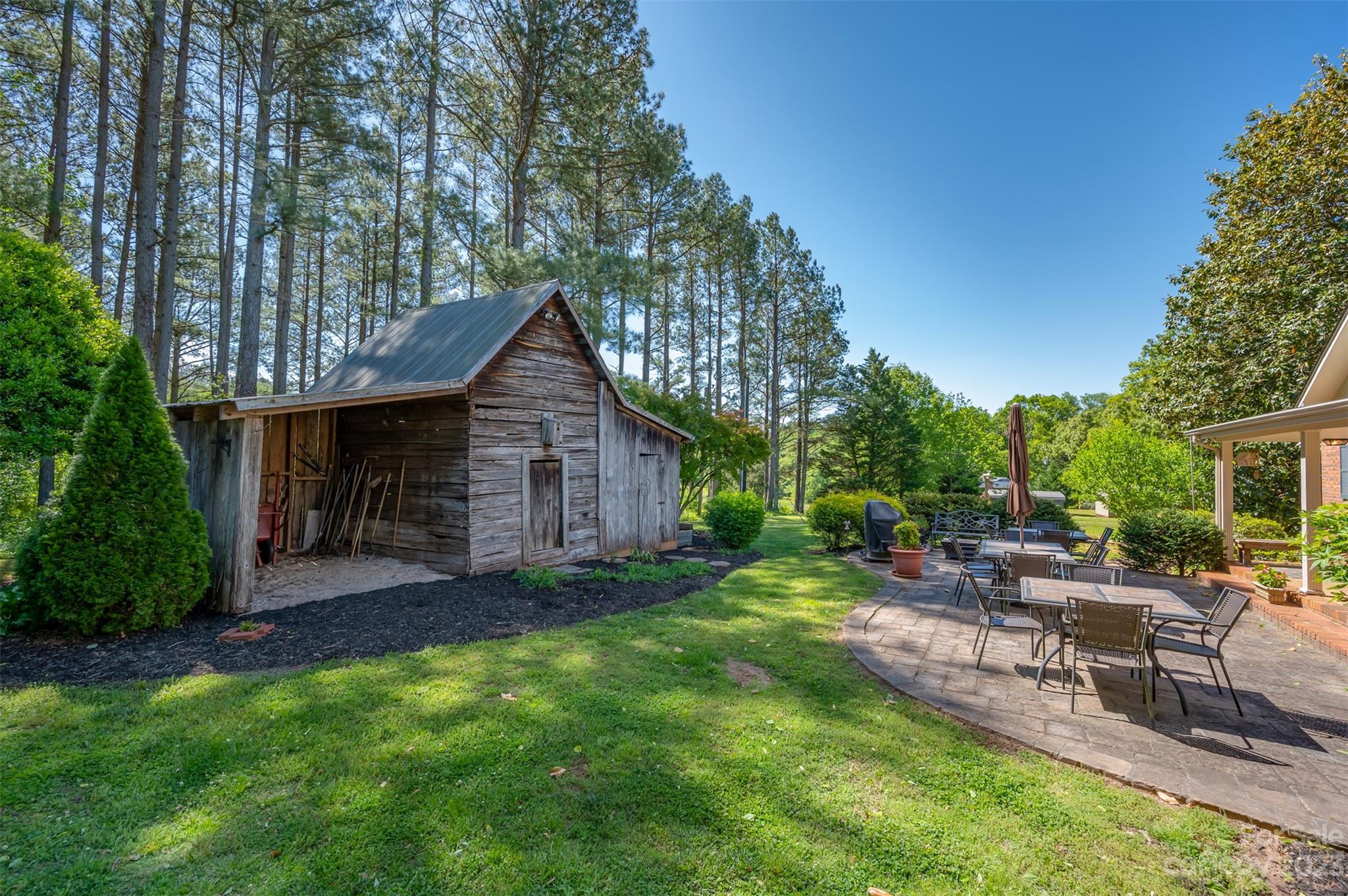 231 Old Gilbert Town Road Rutherfordton, NC 28139 - Photo 26 of 48 a view of a backyard with table and chairs potted plants and a large tree