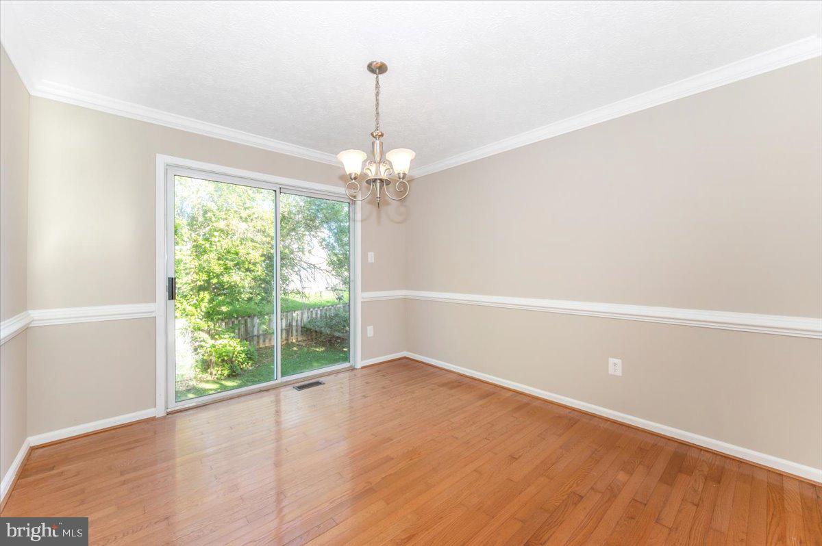 5004 Finch Court Frederick, MD 21703 - Photo 12 of 63 a view of a room with window wooden floor and chandelier