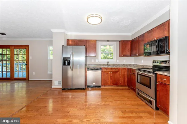 a kitchen with stainless steel appliances granite countertop wooden cabinets stove a sink and dishwasher