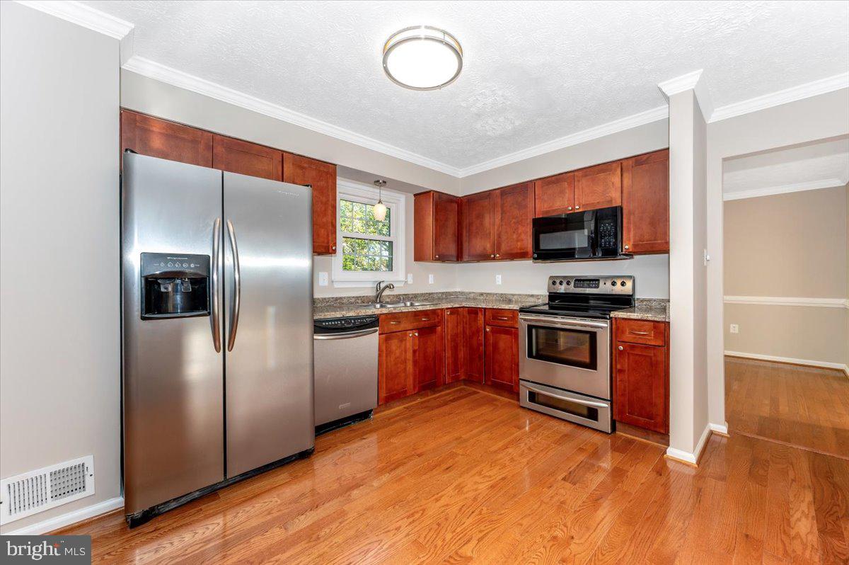 5004 Finch Court Frederick, MD 21703 - Photo 17 of 63 a kitchen with stainless steel appliances and wooden floor