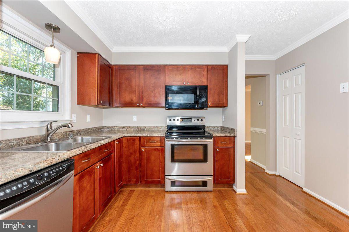 5004 Finch Court Frederick, MD 21703 - Photo 19 of 63 a kitchen with stainless steel appliances granite countertop a stove a sink and a microwave