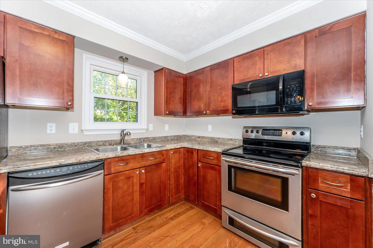 5004 Finch Court Frederick, MD 21703 - Photo 20 of 63 a kitchen with stainless steel appliances granite countertop wooden cabinets stove a sink and dishwasher