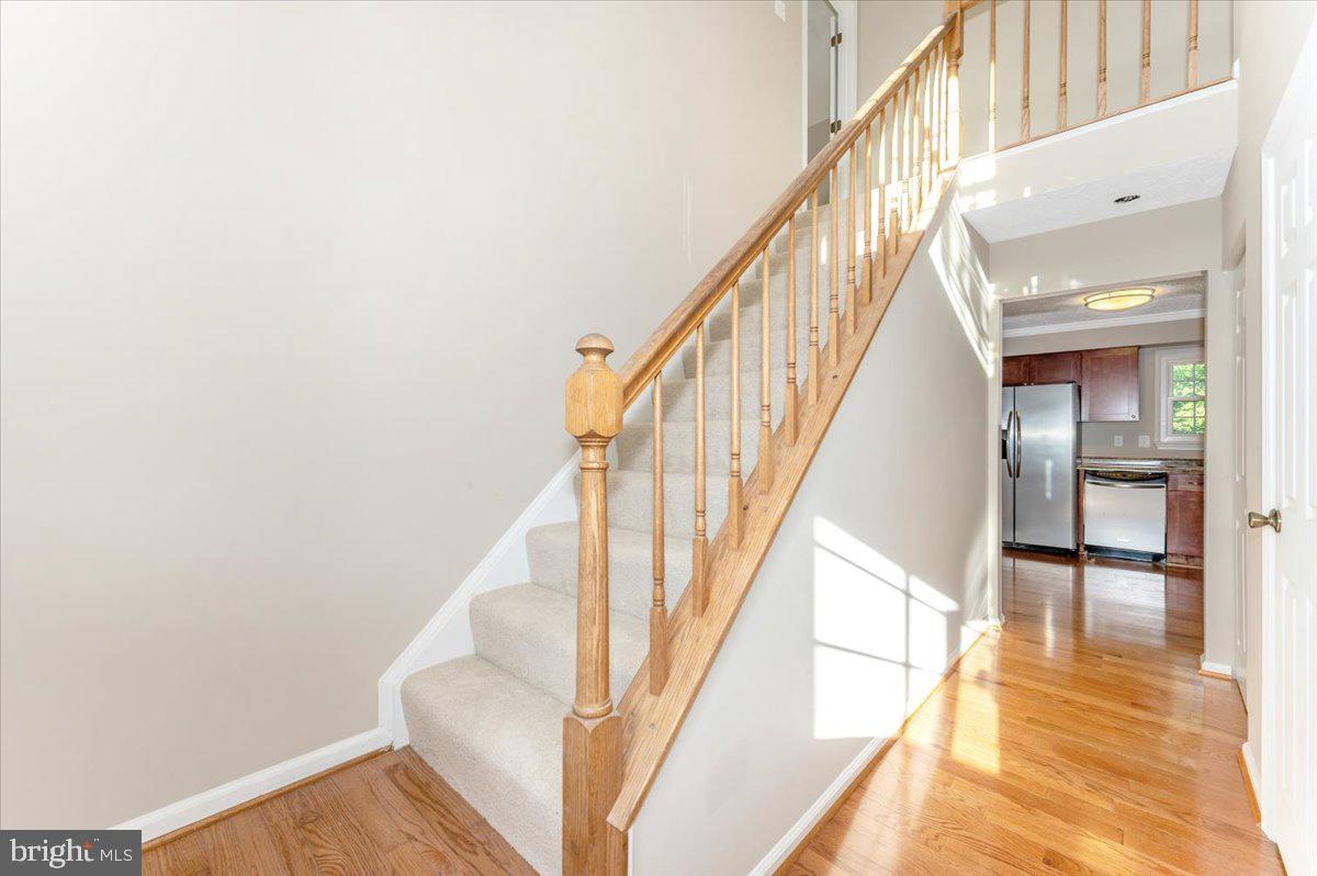 5004 Finch Court Frederick, MD 21703 - Photo 5 of 63 a view of staircase with lots of frames on wall and wooden floor