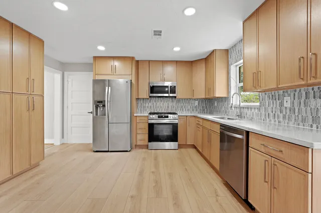 a kitchen with stainless steel appliances a refrigerator sink and cabinets
