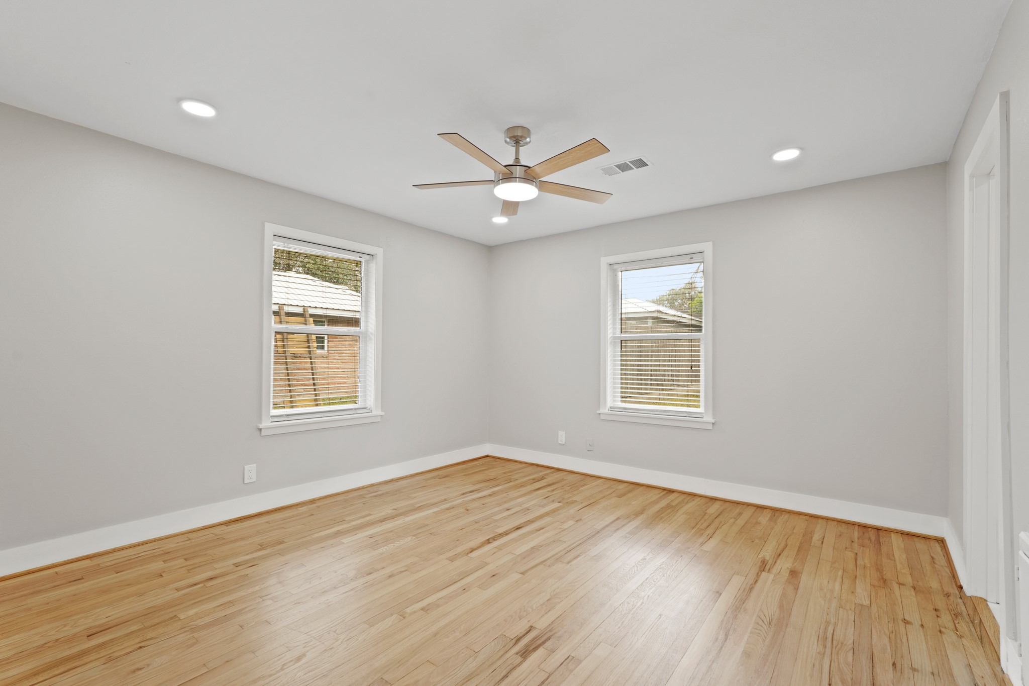 5451 Redstart Street Houston, TX 77096 - Photo 17 of 23 an empty room with wooden floor ceiling fan and windows