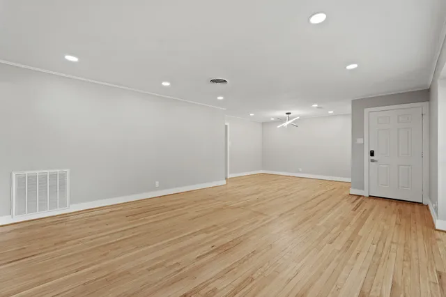 a view of an empty room with wooden floor