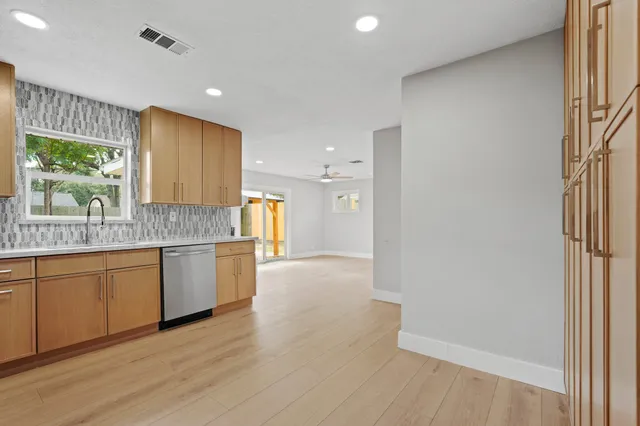 a kitchen with granite countertop a stove a sink and a refrigerator