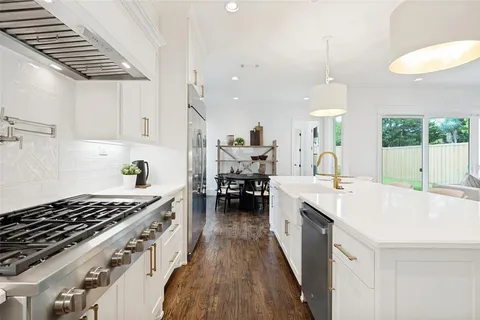 a kitchen with a stove a sink a dining table and chairs