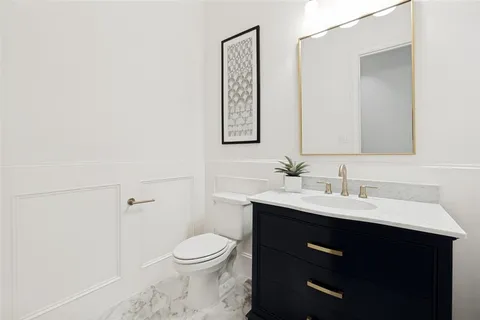 a bathroom with a toilet a sink and mirror
