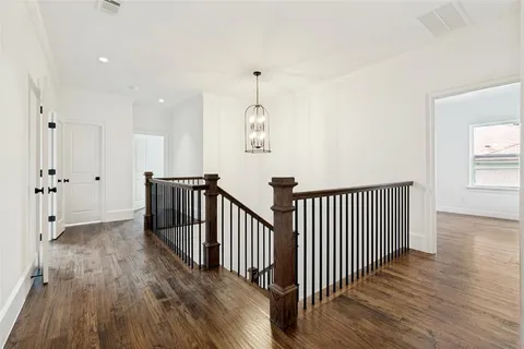 a view of a hallway with wooden floor and windows