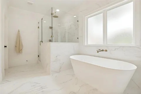 a white bath tub sitting in a bathroom and shower