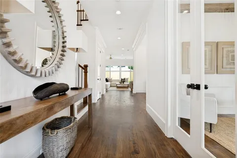 a walk in closet with wooden floor and windows