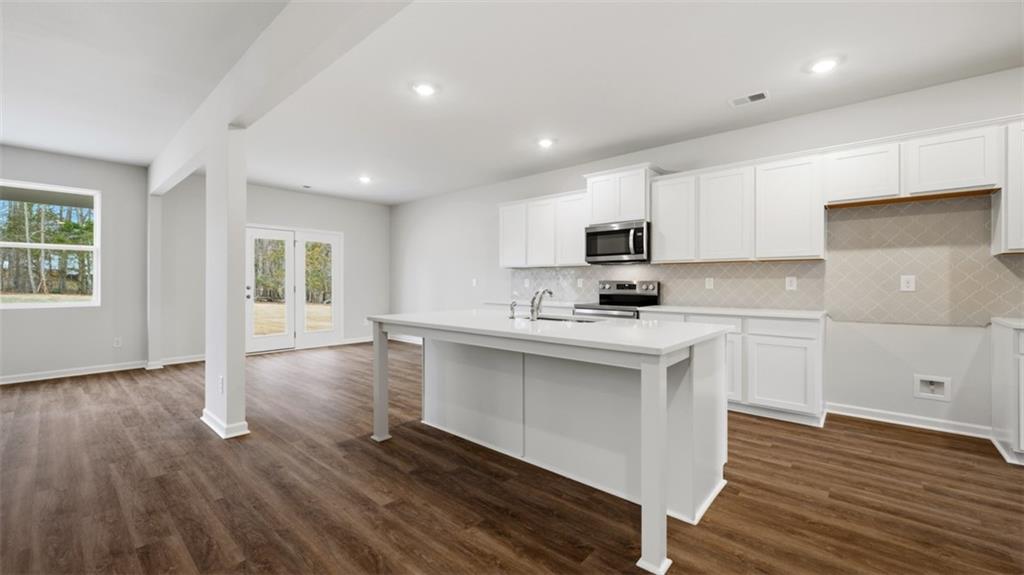 504 Bullock Pass Jefferson, GA 30549 - Photo 7 of 54 a kitchen with wooden floors and white cabinets