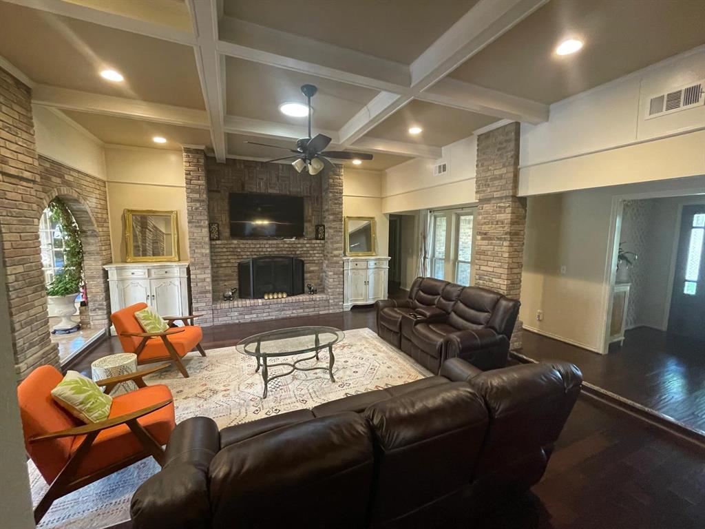 3612 Cross Bend Road Plano, TX 75023 - Photo 8 of 38 Living room featuring a healthy amount of sunlight, a brick fireplace, hardwood / wood-style floors, and beam ceiling