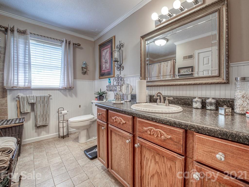 2823 Bettis Road Grover, NC 28073 - Photo 17 of 27 a bathroom with a granite countertop sink a toilet and mirror