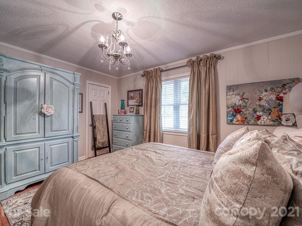 2823 Bettis Road Grover, NC 28073 - Photo 18 of 27 a bedroom with a large bed and a chandelier
