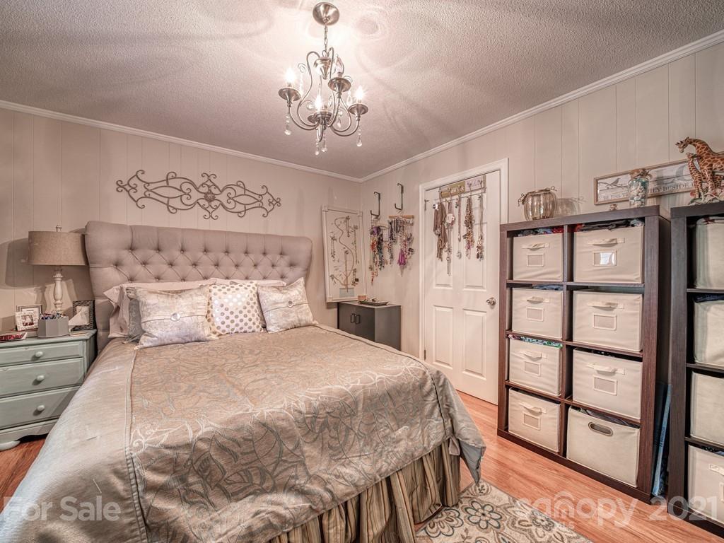 2823 Bettis Road Grover, NC 28073 - Photo 20 of 27 a bedroom with a large bed and a chandelier