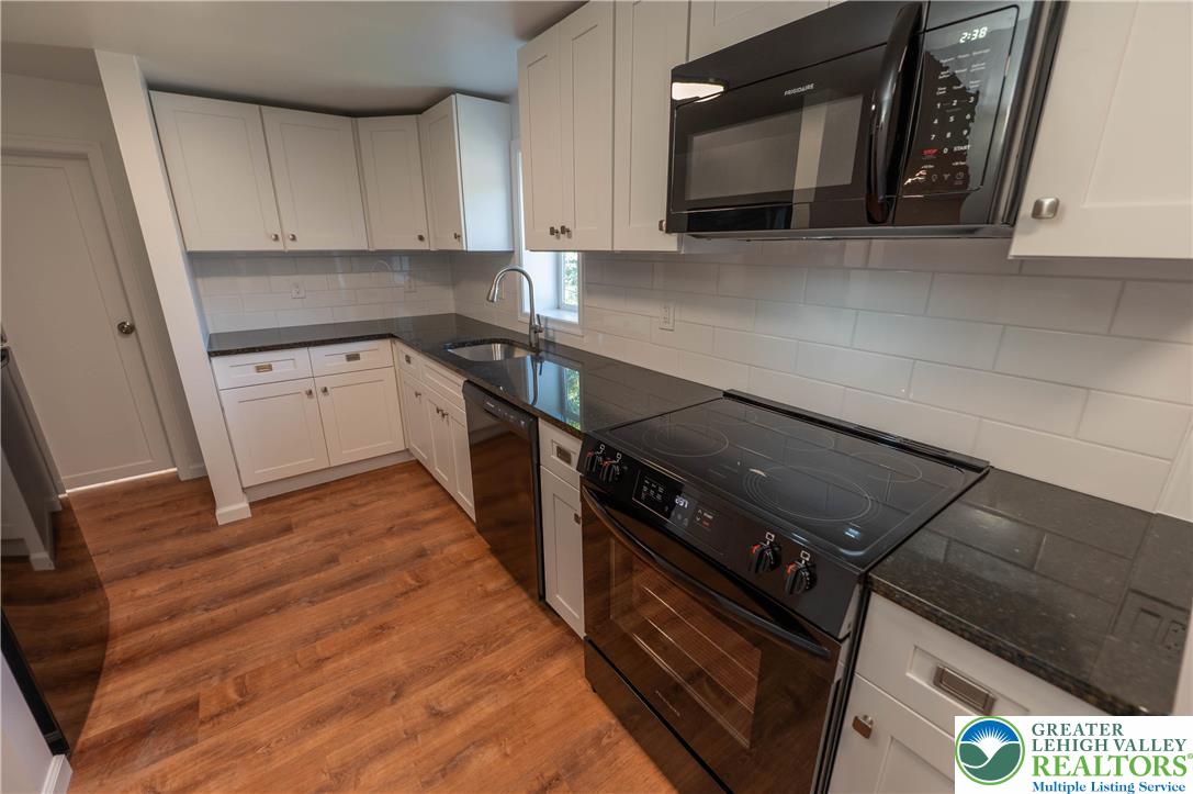 1261 State Street, Unit C Mertztown, PA 19539 - Photo 7 of 13 a kitchen with granite countertop a stove and a microwave