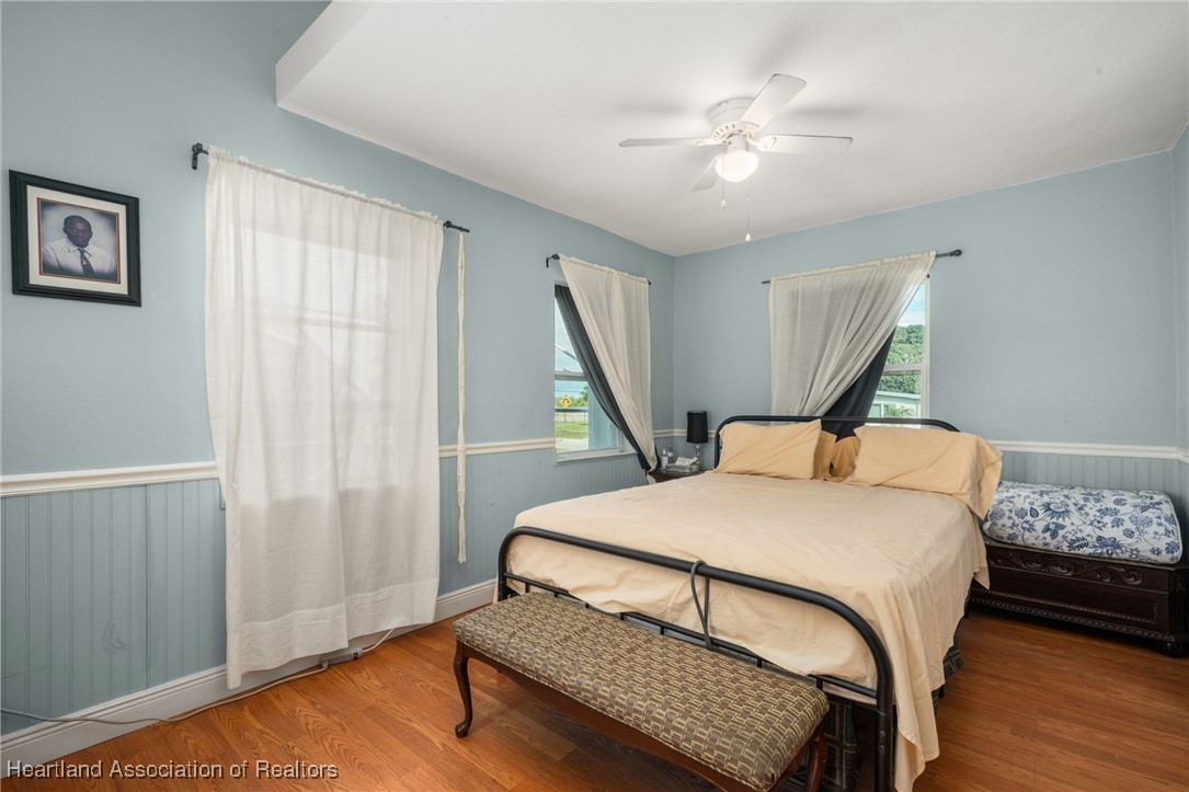 1612 Hitakee Avenue Sebring, FL 33870 - Photo 14 of 32 a bedroom with a bed a dresser and wooden floor