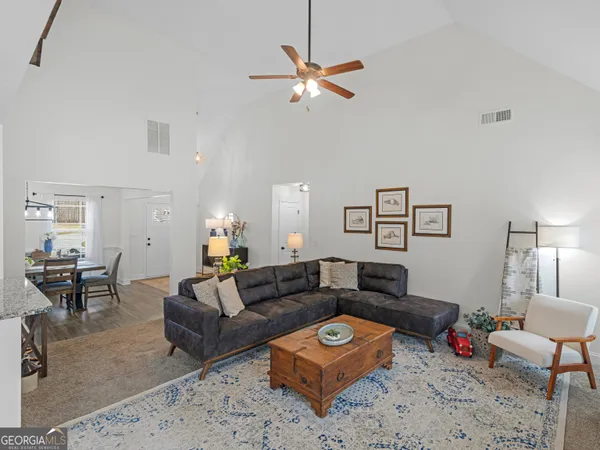 a living room with furniture and kitchen view