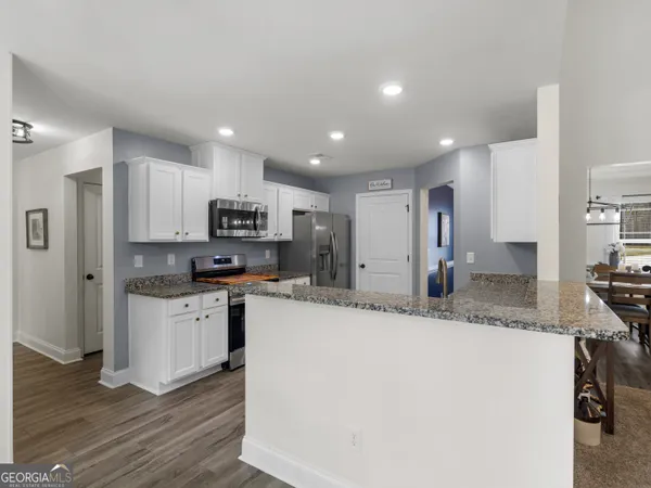 a kitchen with white cabinets sink and stove