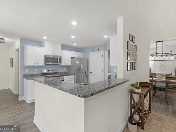 a kitchen with a sink cabinets and wooden floor