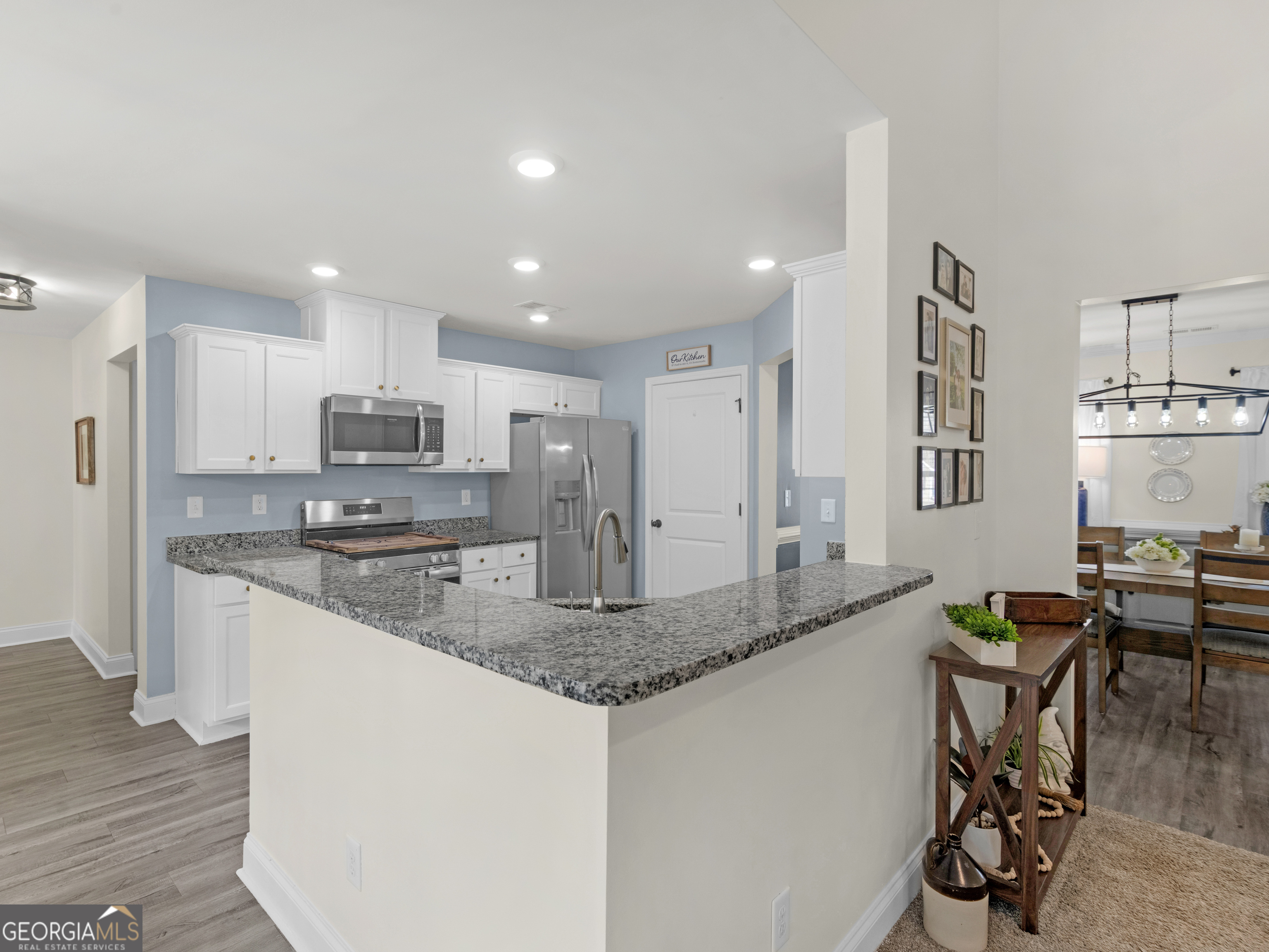 119 Mylee Cove Barnesville, GA 30204 - Photo 23 of 57 a kitchen with stainless steel appliances granite countertop a stove a sink a microwave a dining table and chairs