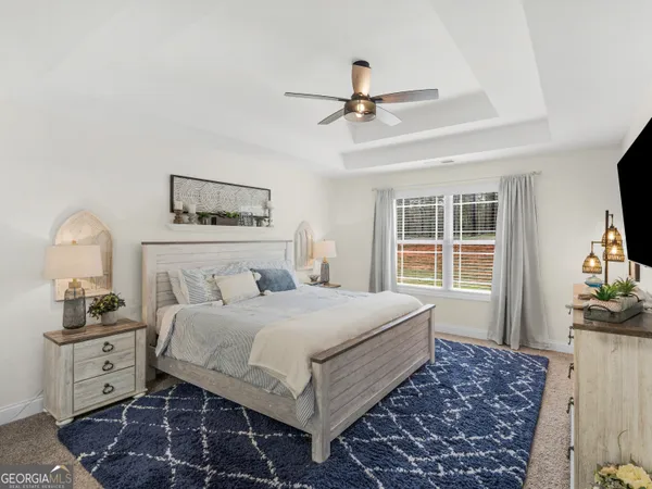a bedroom with a bed a flat screen tv and a chandelier