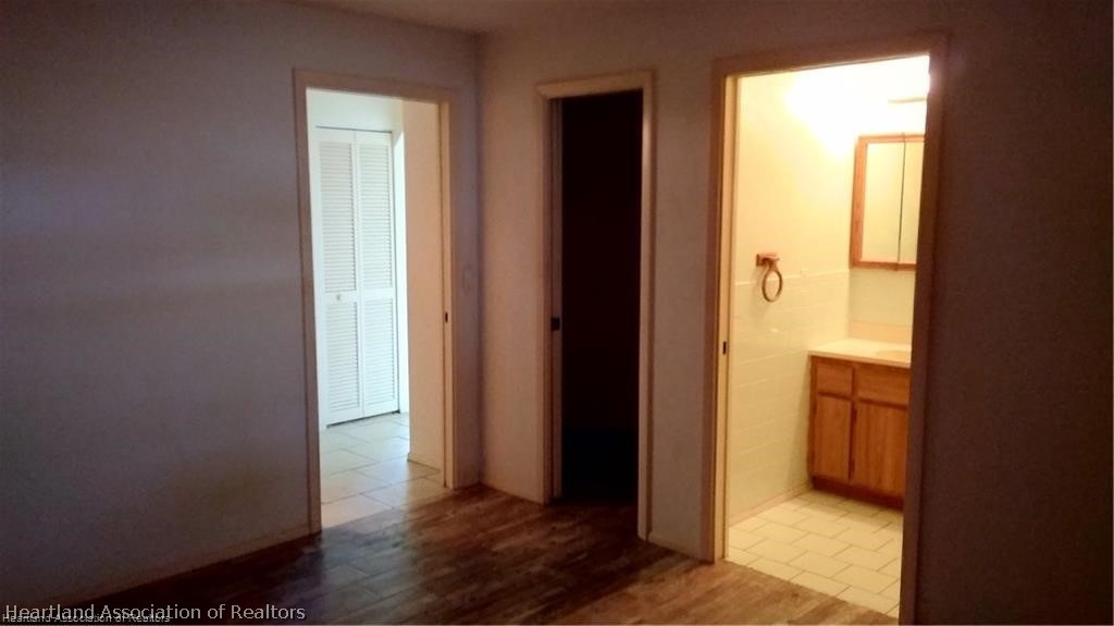 4111 Leaf Road Sebring, FL 33875 - Photo 7 of 8 a view of an empty room with wooden floor and a window