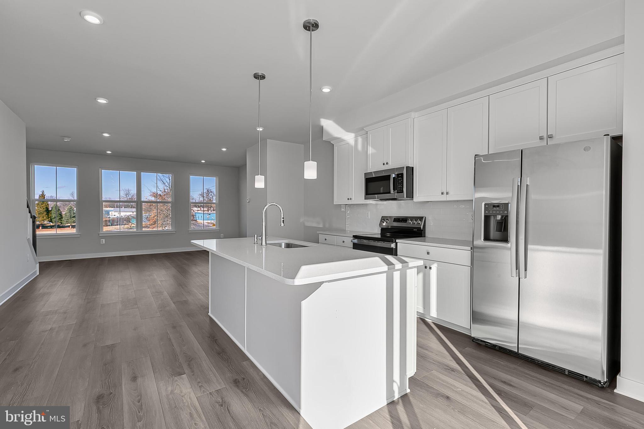 1 E Oasis Avenue Ranson, WV 25438 - Photo 14 of 38 a kitchen with stainless steel appliances granite countertop a refrigerator a sink dishwasher a stove and white countertops with wooden floor