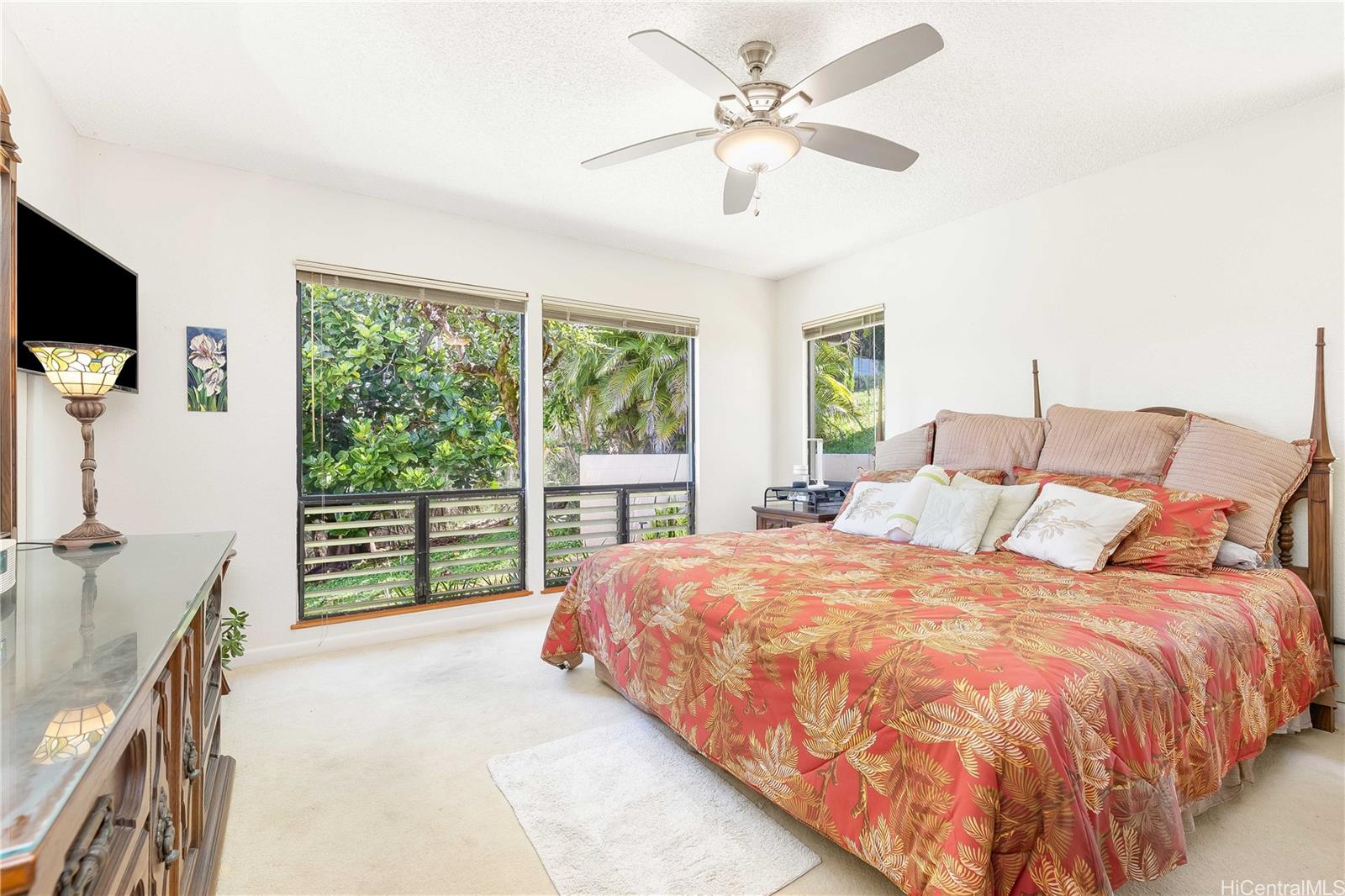 98-1421 Onikiniki Place, Unit 5 Aiea, HI 96701 - Photo 12 of 25 a bedroom with a bed and a flat tv screen on dresser