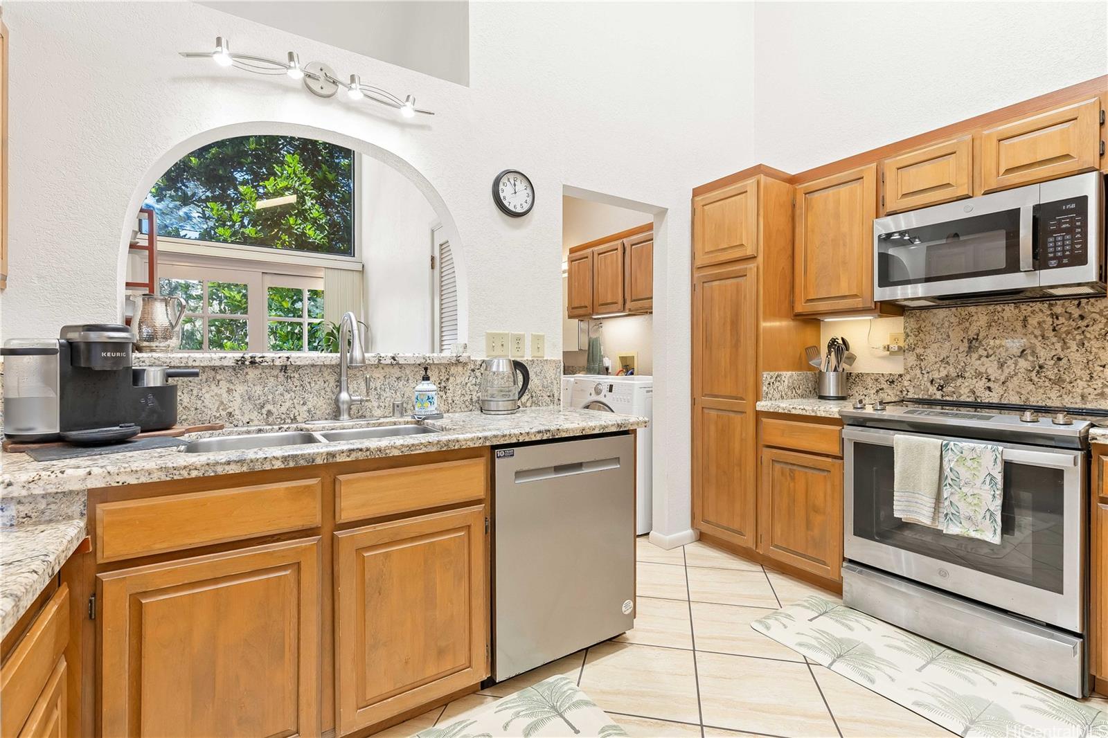 98-1421 Onikiniki Place, Unit 5 Aiea, HI 96701 - Photo 7 of 25 a kitchen with stainless steel appliances granite countertop a stove a sink and a microwave