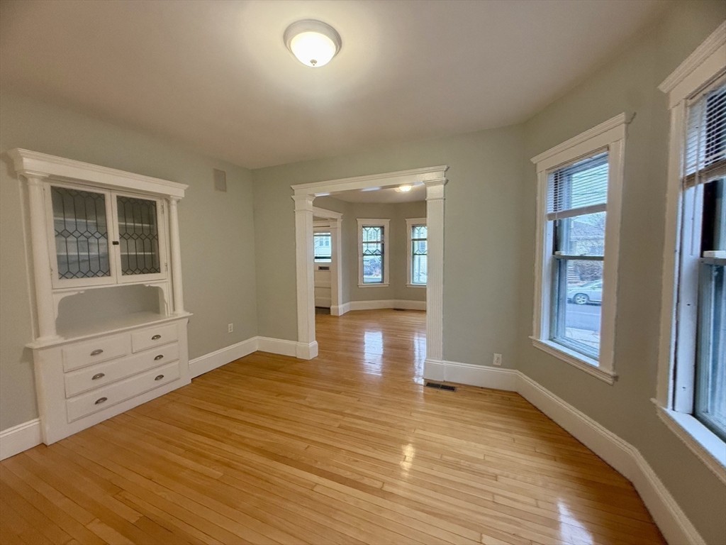 172 Maplewood Street, Unit 172 Watertown, MA 02472 - Photo 11 of 29 wooden floor in an empty room with a window