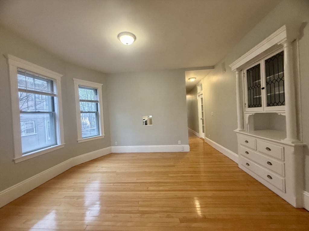 172 Maplewood Street, Unit 172 Watertown, MA 02472 - Photo 13 of 29 a view of an empty room with window and wooden floor