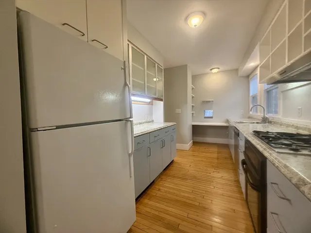 a large kitchen with stainless steel appliances a refrigerator and a stove