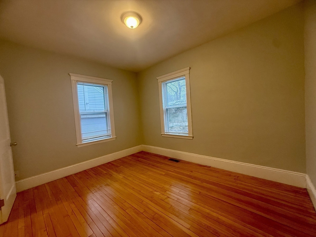 172 Maplewood Street, Unit 172 Watertown, MA 02472 - Photo 24 of 29 a view of an empty room with wooden floor and a window