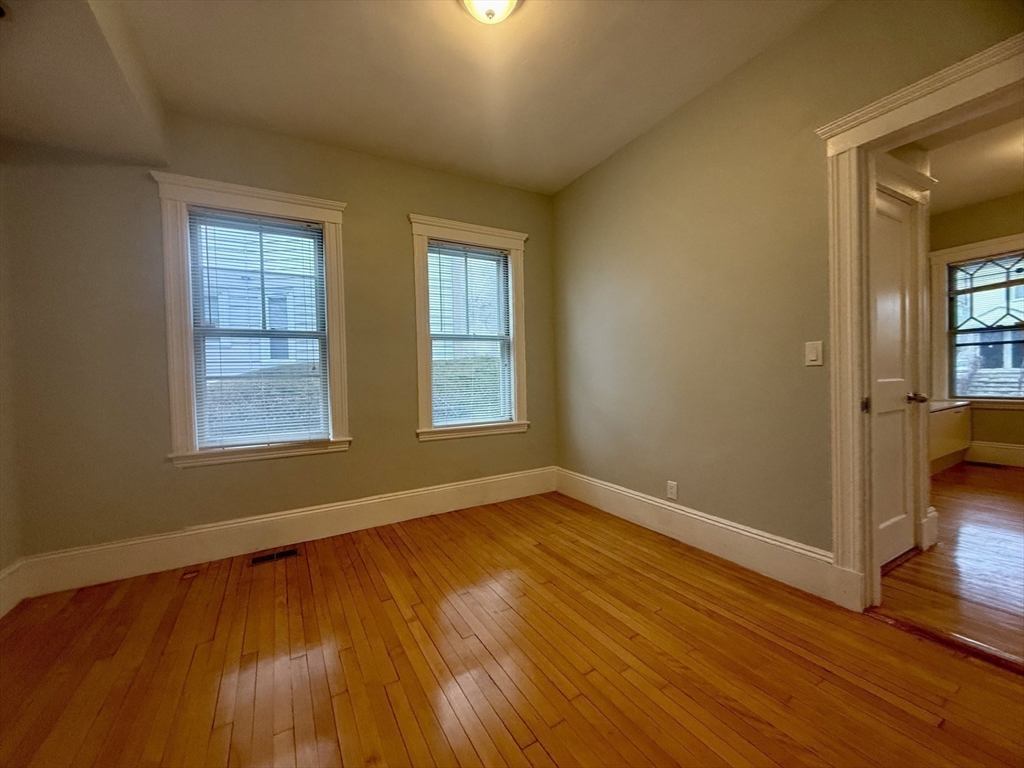 172 Maplewood Street, Unit 172 Watertown, MA 02472 - Photo 4 of 29 a view of an empty room with wooden floor and a window